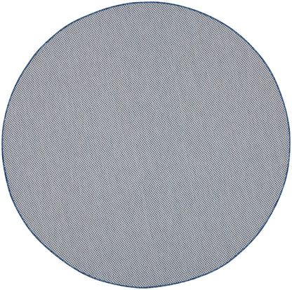 Round blue-gray rug with a fine dotted weave and navy border.