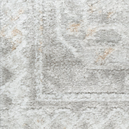 Close-up of a light gray shag rug with plush pile and subtle ivory-beige pattern along the border.