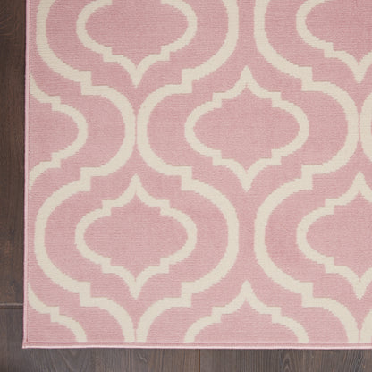 Pink rug with white trellis pattern on dark wood floor; soft pink border along edge.
