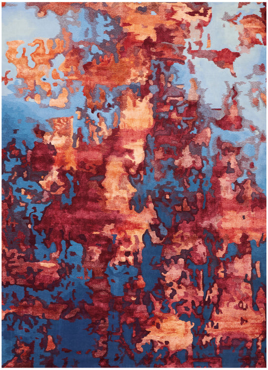 Abstract patterned area rug in warm orange-rust tones with blue and teal patches; modern, art-inspired design.