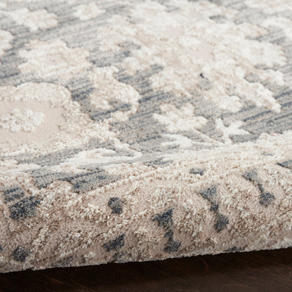 Soft high-pile rug in beige and gray with a subtle floral/medallion pattern; folded edge shows plush fibers.