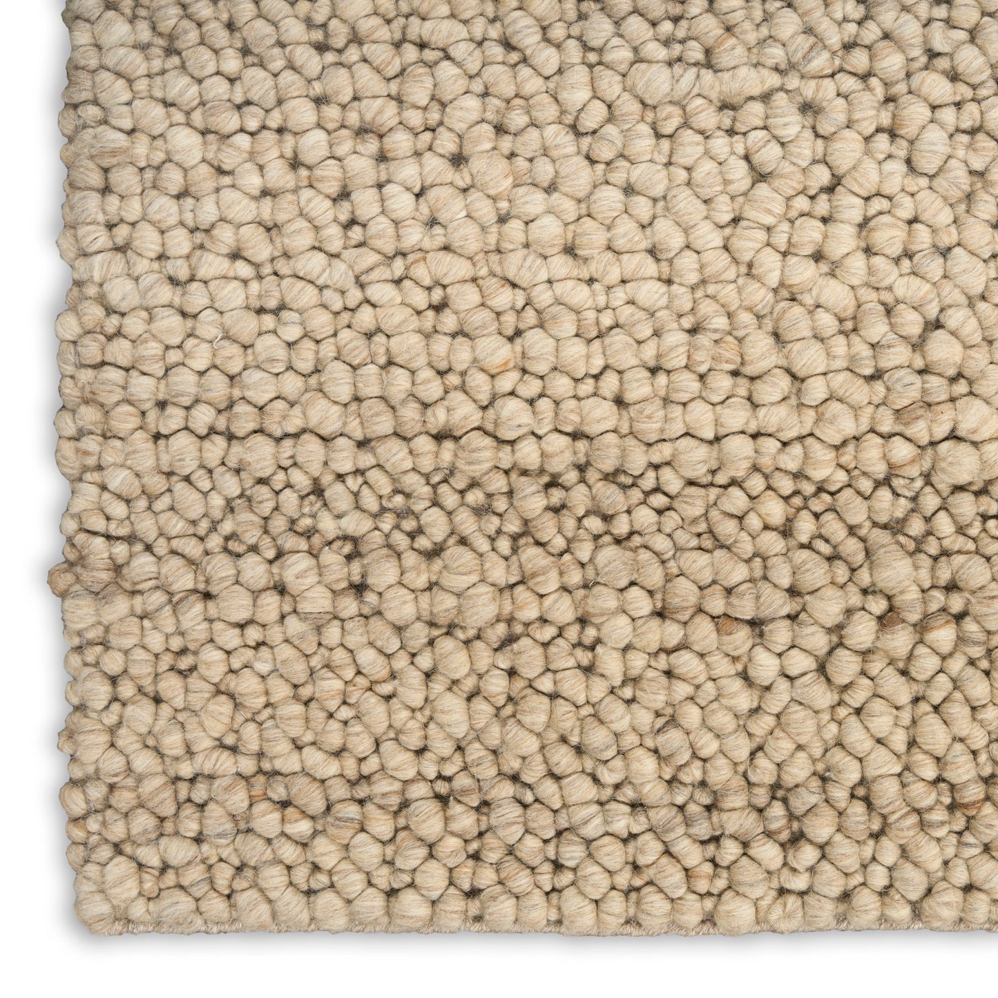Beige loop-pile rug close-up; dense tufted texture with cream-tan fibers, soft and plush.
