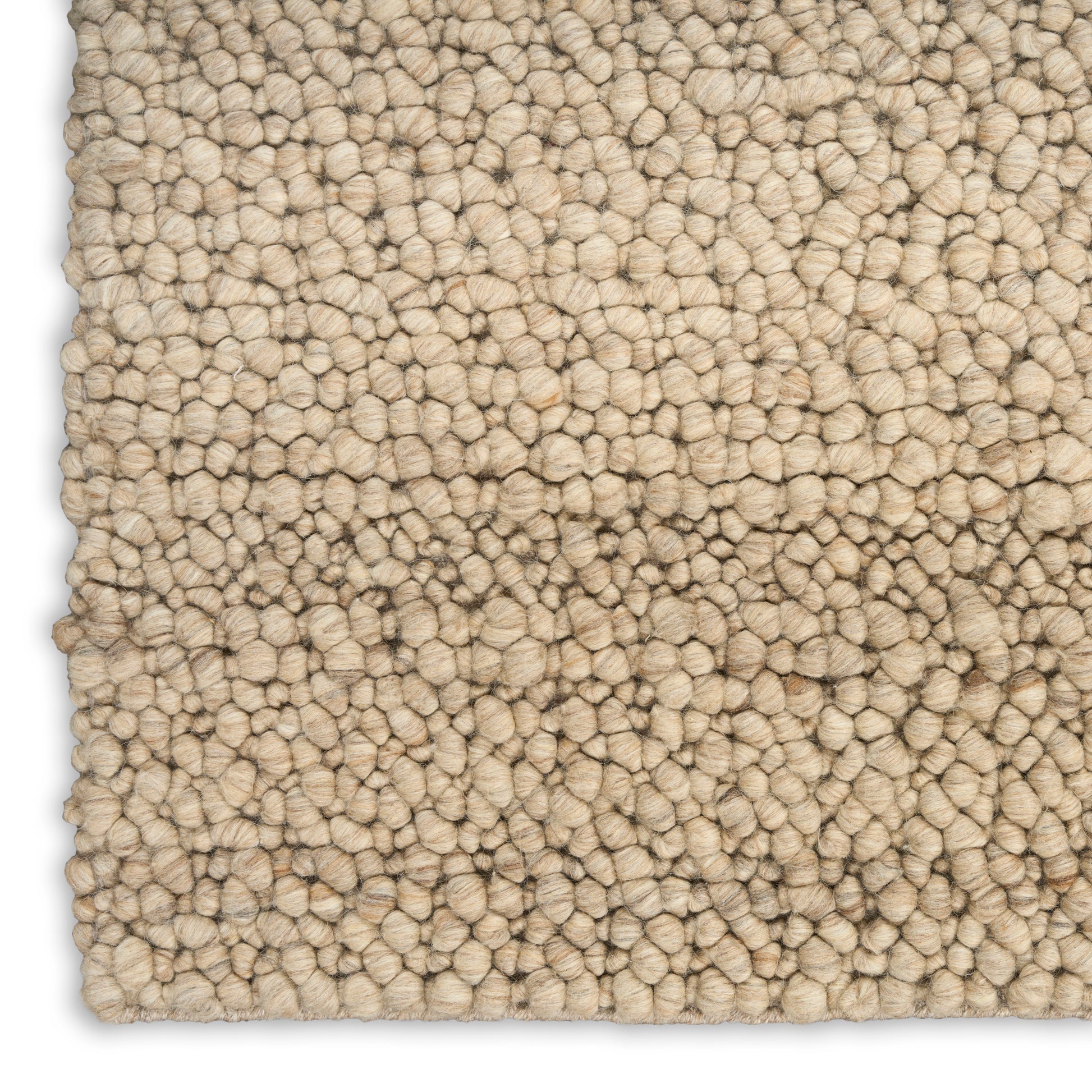 Beige loop-pile rug close-up; dense tufted texture with cream-tan fibers, soft and plush.