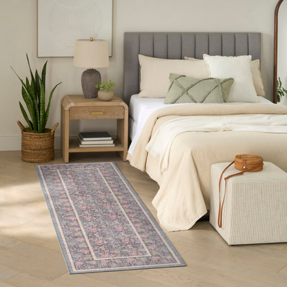 Cozy neutral bedroom with a gray upholstered headboard, cream bedding, wooden nightstand, rug runner, and woven ottoman.