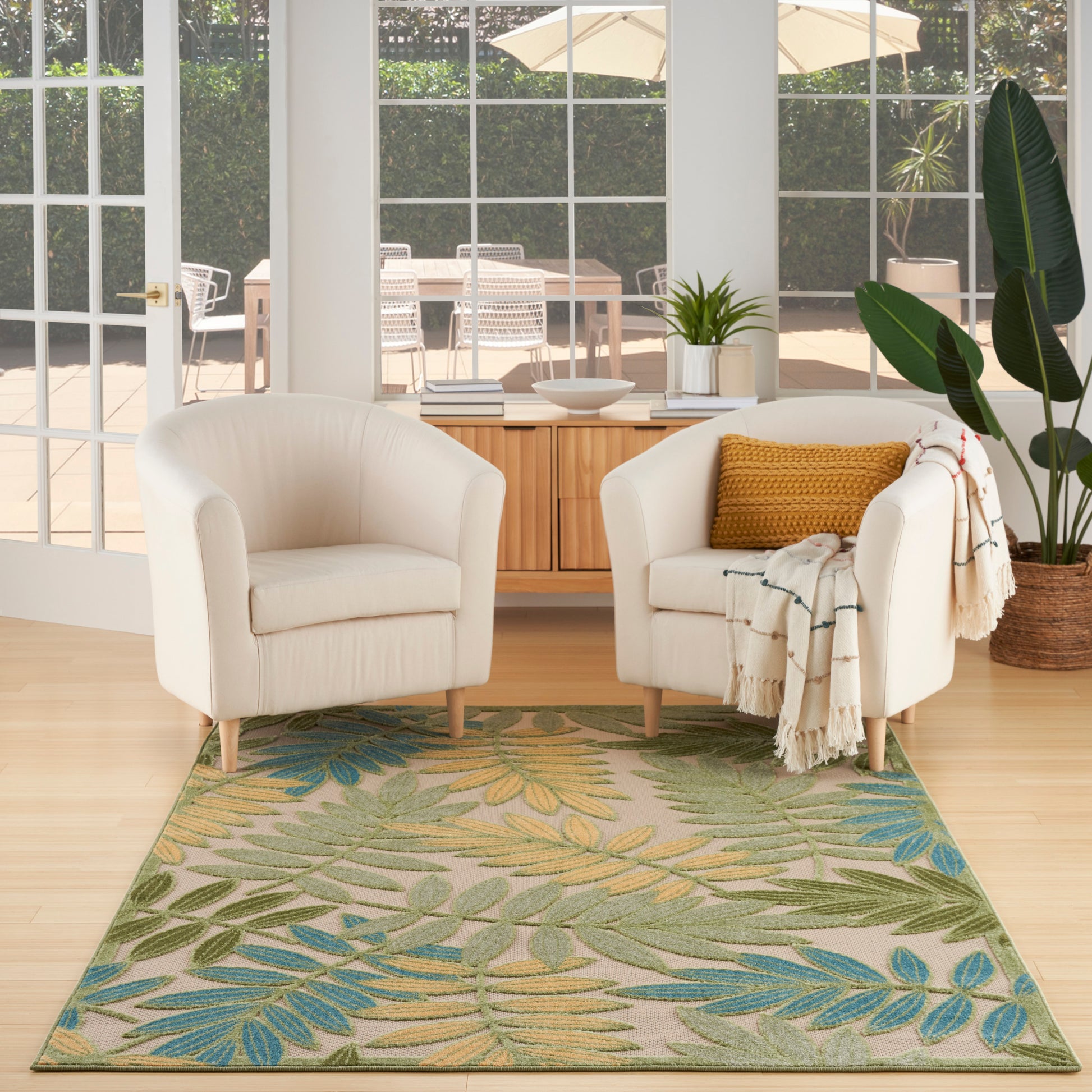 Outdoor rug with tropical leaf pattern in green, yellow and blue, 6' x 9'.