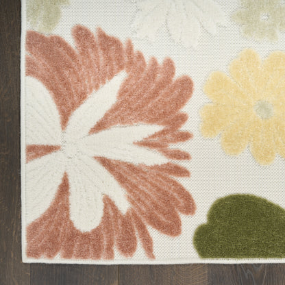 Floral rug with large red-orange petals, white center, yellow flower and green leaf on cream background; wooden floor edge.