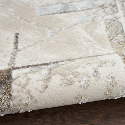 Beige abstract area rug with geometric lines and light blue accents, folded corner on dark wood floor.