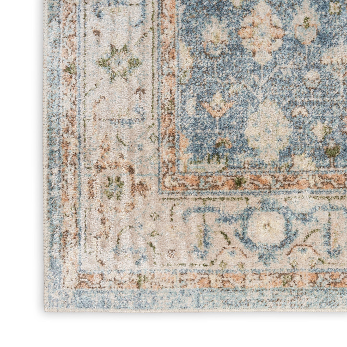 Distressed blue and beige oriental area rug with floral border and muted orange accents.