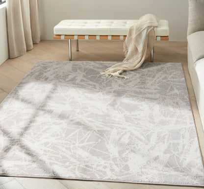 Rectangular light-gray abstract rug on wood floor; cream tufted bench with wooden slats & metal legs, beige throw draped.
