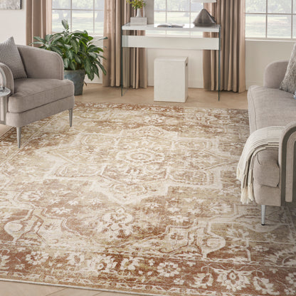 Beige oriental rug with cream and brown floral motif in a living room with light gray sofas, glass console table, and plants.
