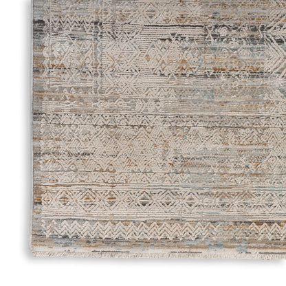 Distressed geometric boho rug in ivory, beige, taupe with pale blue accents and fringed border.