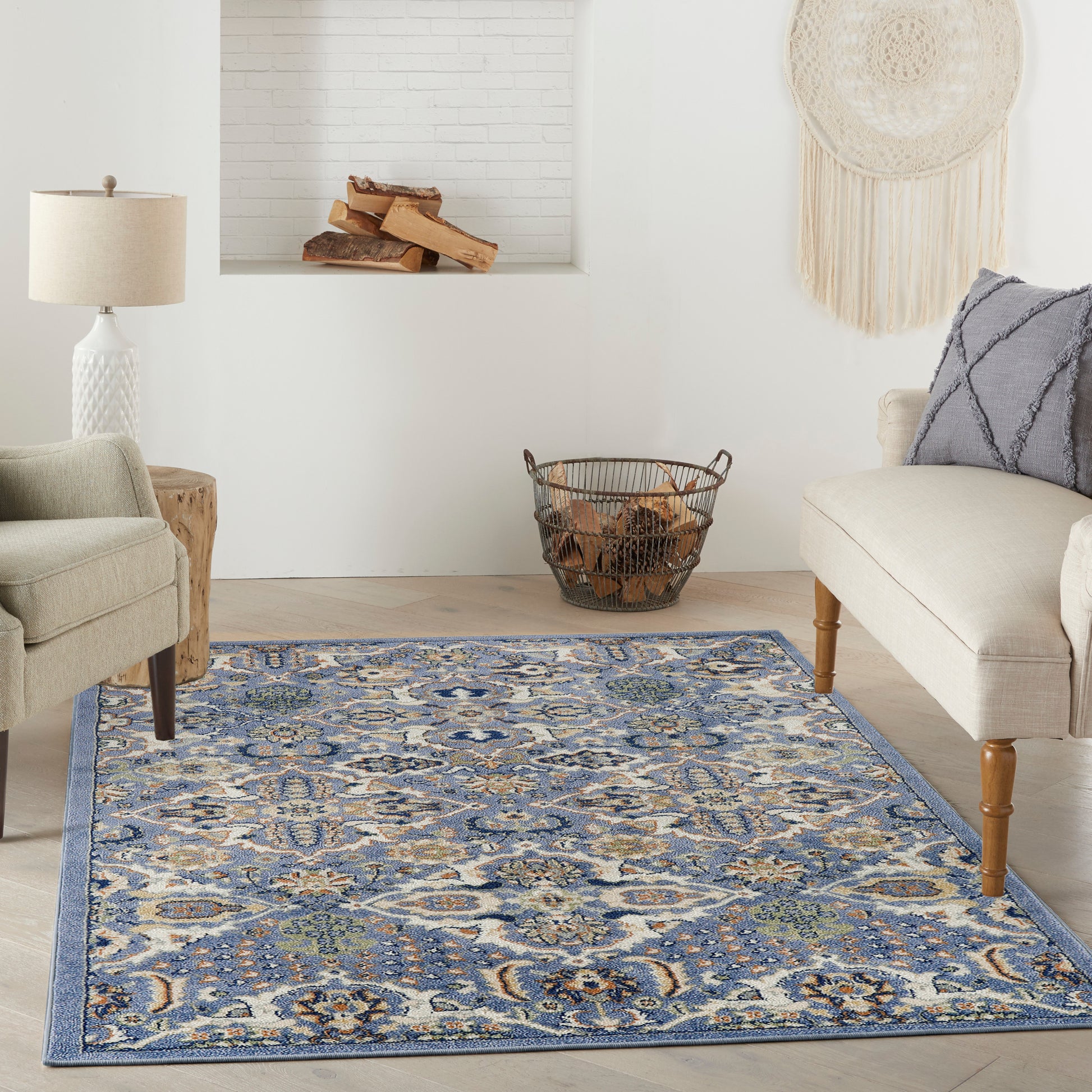 Blue and ivory patterned woven area rug in a cozy living room with beige sofas and wooden accents.