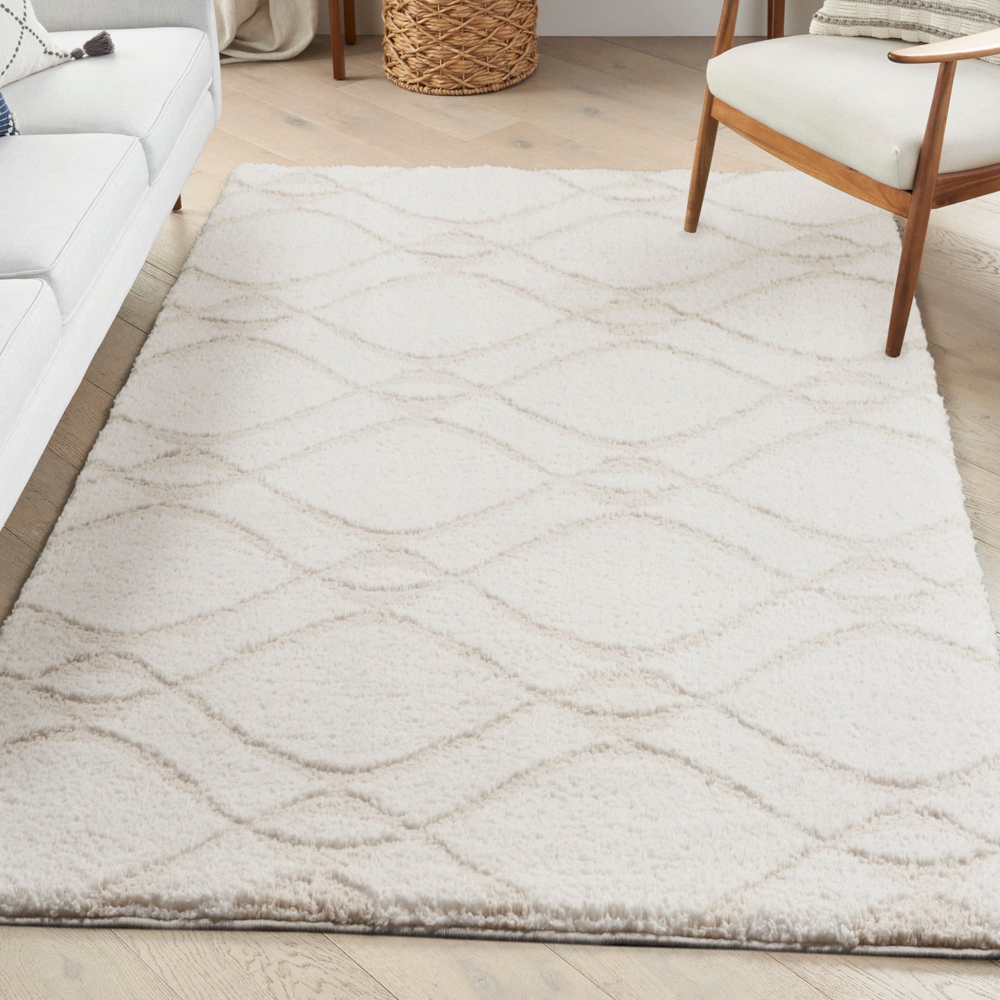 Cream shag rug with beige wavy lines in a bright living room; sofa, wooden chair, and woven basket.