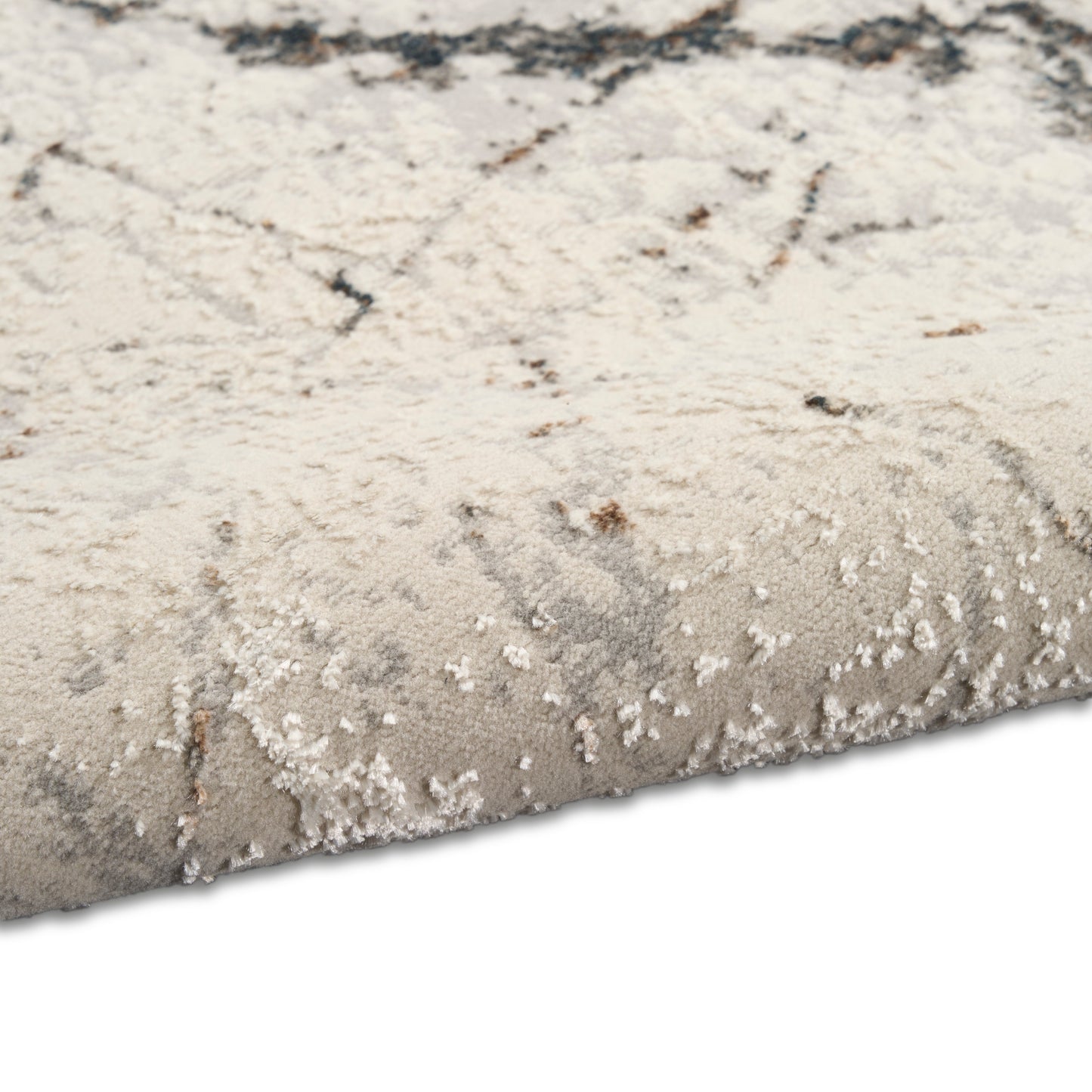 Beige and gray abstract-pattern area rug with plush pile and rolled edge.