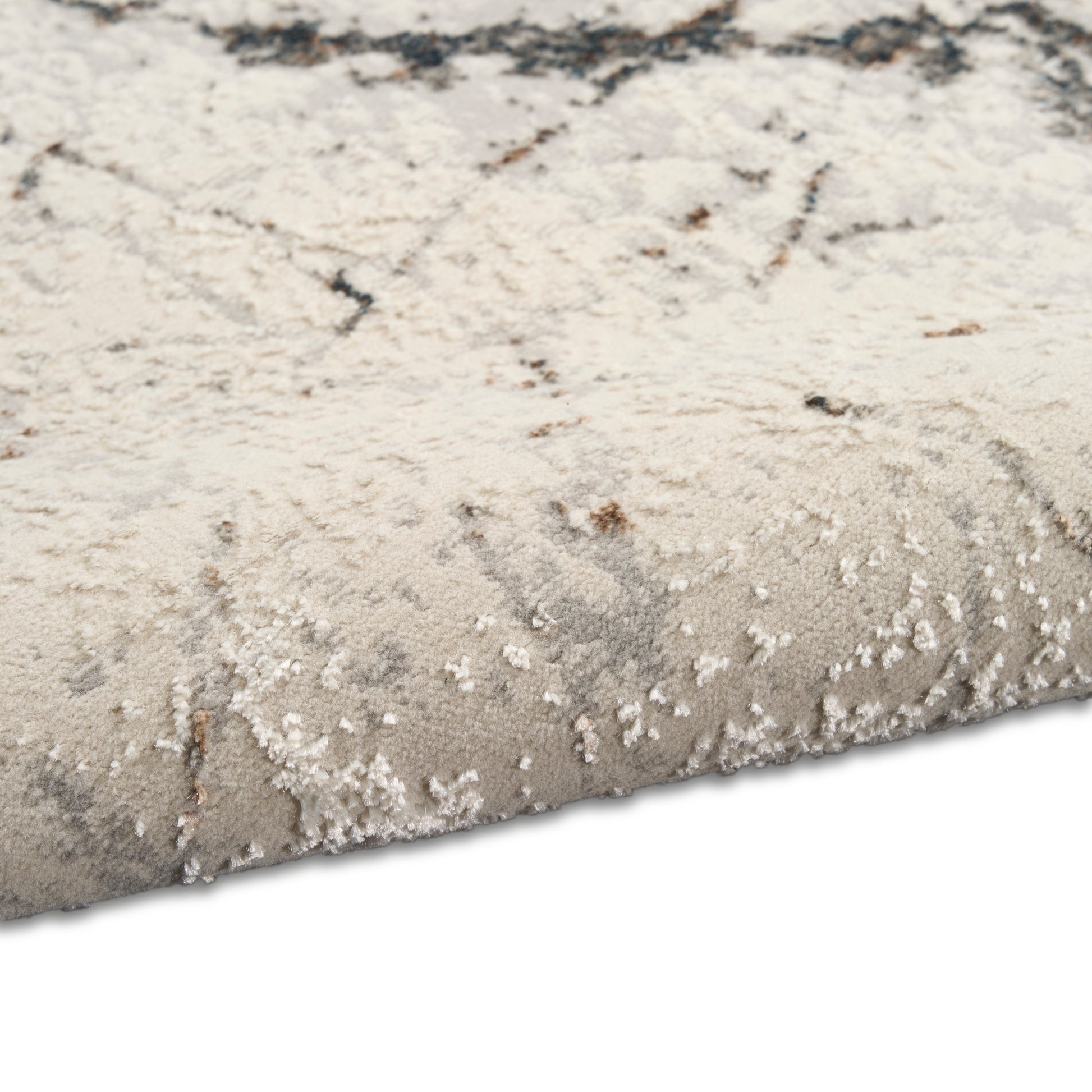 Beige and gray abstract-pattern area rug with plush pile and rolled edge.