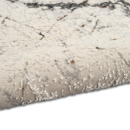 Beige and gray abstract-pattern area rug with plush pile and rolled edge.