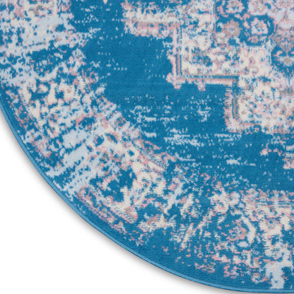 Round blue area rug with pink & white distressed motif & blue edge binding.