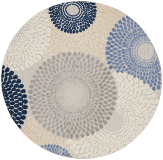 Round rug with radiating dotburst circles in navy, gray and beige; modern geometric area rug for living spaces.