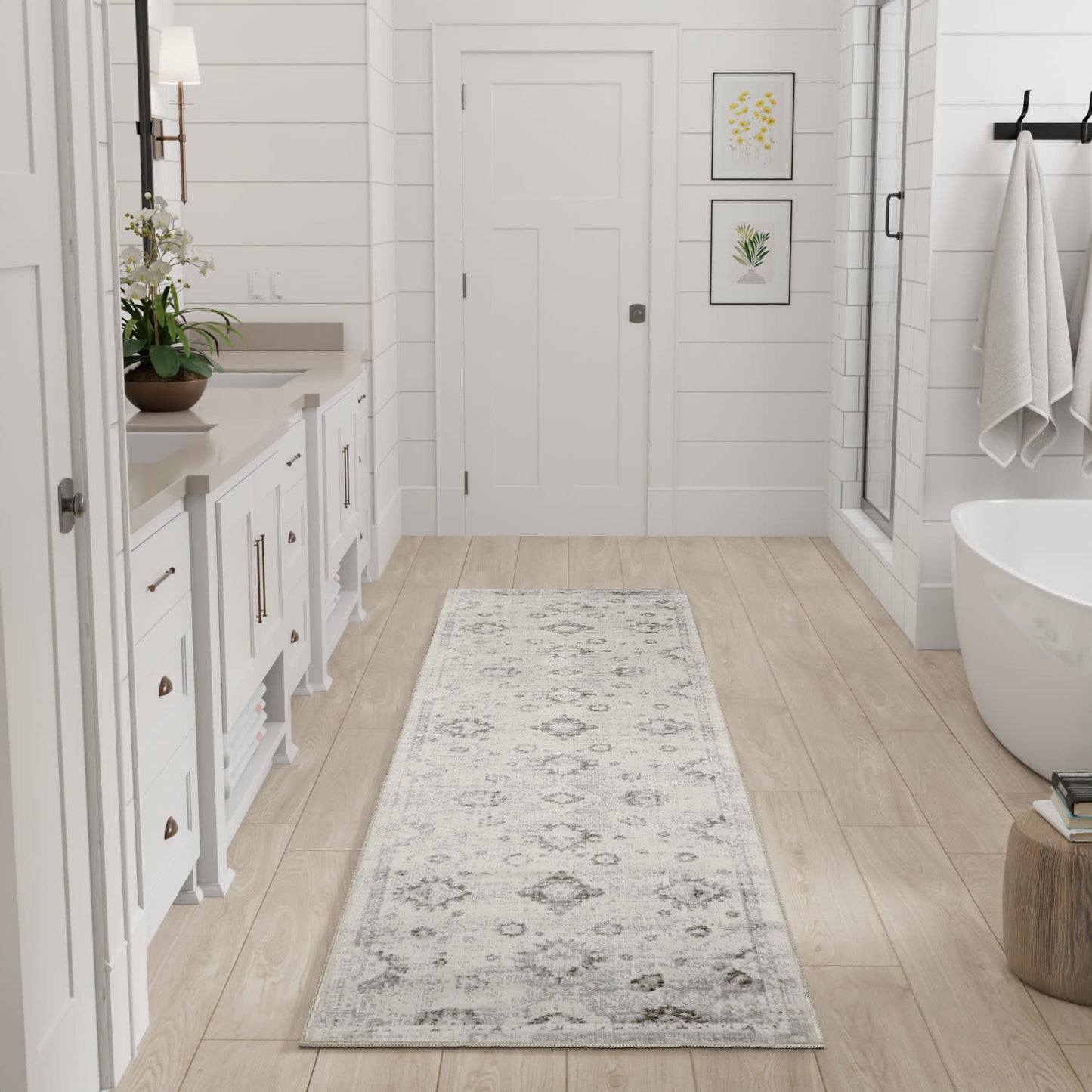 Long light gray patterned runner rug in a bright white farmhouse-style bathroom with a freestanding tub and white cabinetry.
