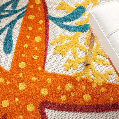 Vibrant shaggy area rug with an orange field dotted in yellow, surrounded by blue and teal accents; white chair leg visible.