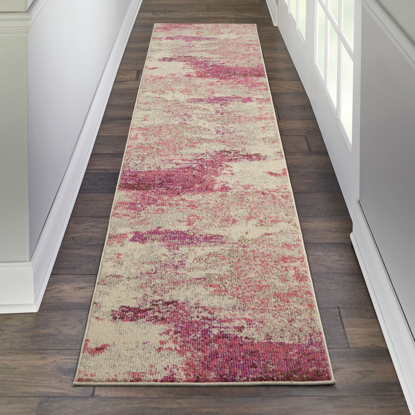 Long rectangular hallway runner rug with cream base and pink-magenta abstract blotches; modern flatweave.