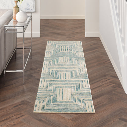 Blue and cream geometric hallway runner rug with square pattern on dark wood floor beside a chrome console table.