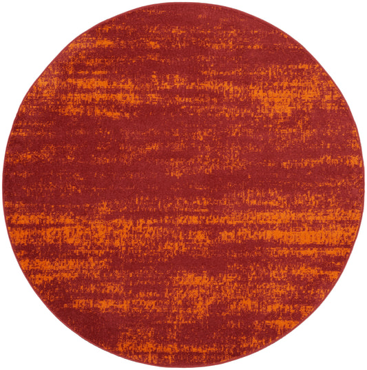 Round rug in warm red and orange tones with distressed texture; contemporary boho style.