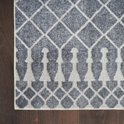 Gray and white geometric area rug with diamond lattice and row of gown-shaped silhouettes along the bottom edge.