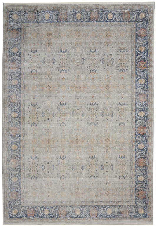 Traditional rug with a blue ornate border and a light gray field dotted with subtle blue, peach and tan floral motifs.