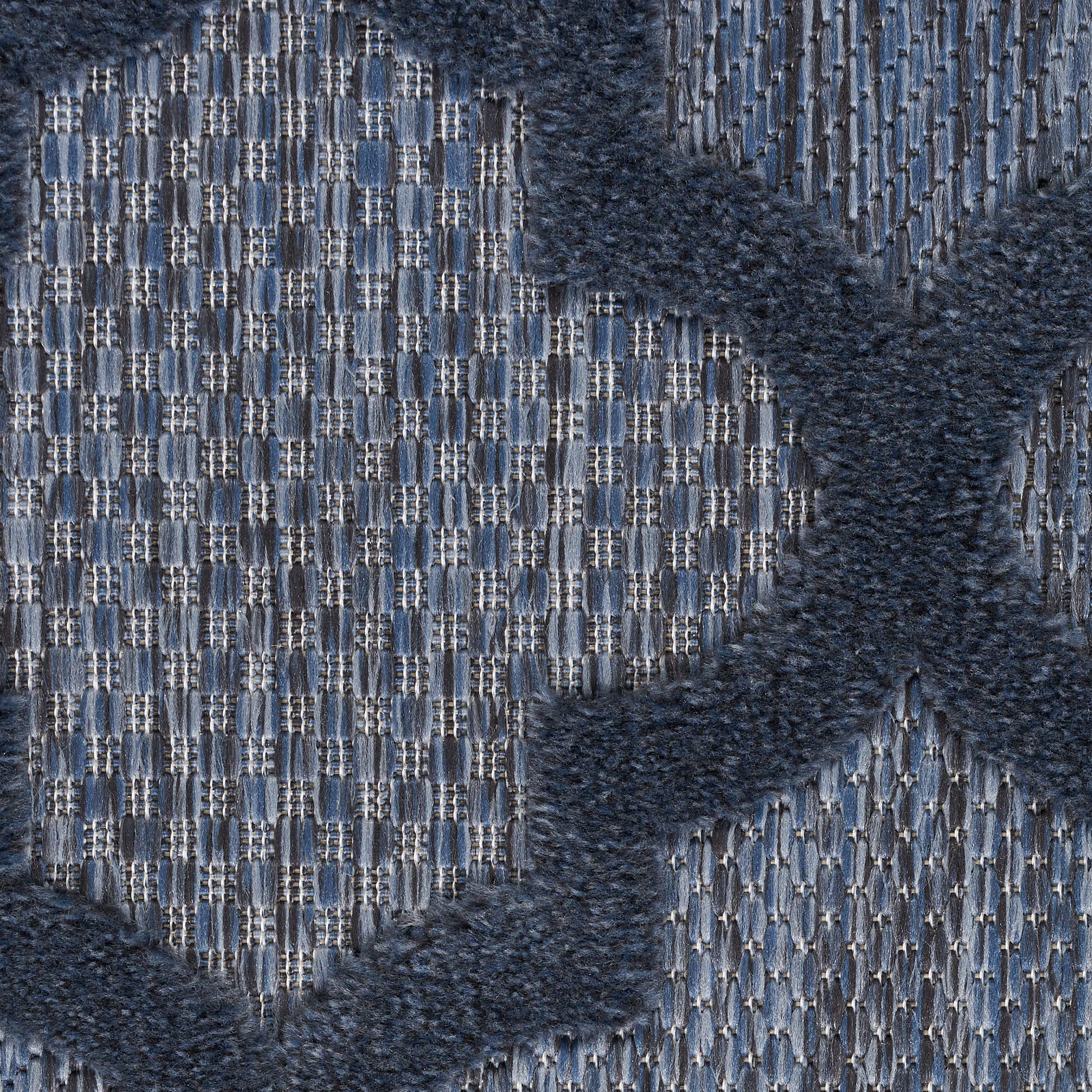 Blue woven rug with a light blue grid pattern and dark navy shaggy X-shaped motifs.
