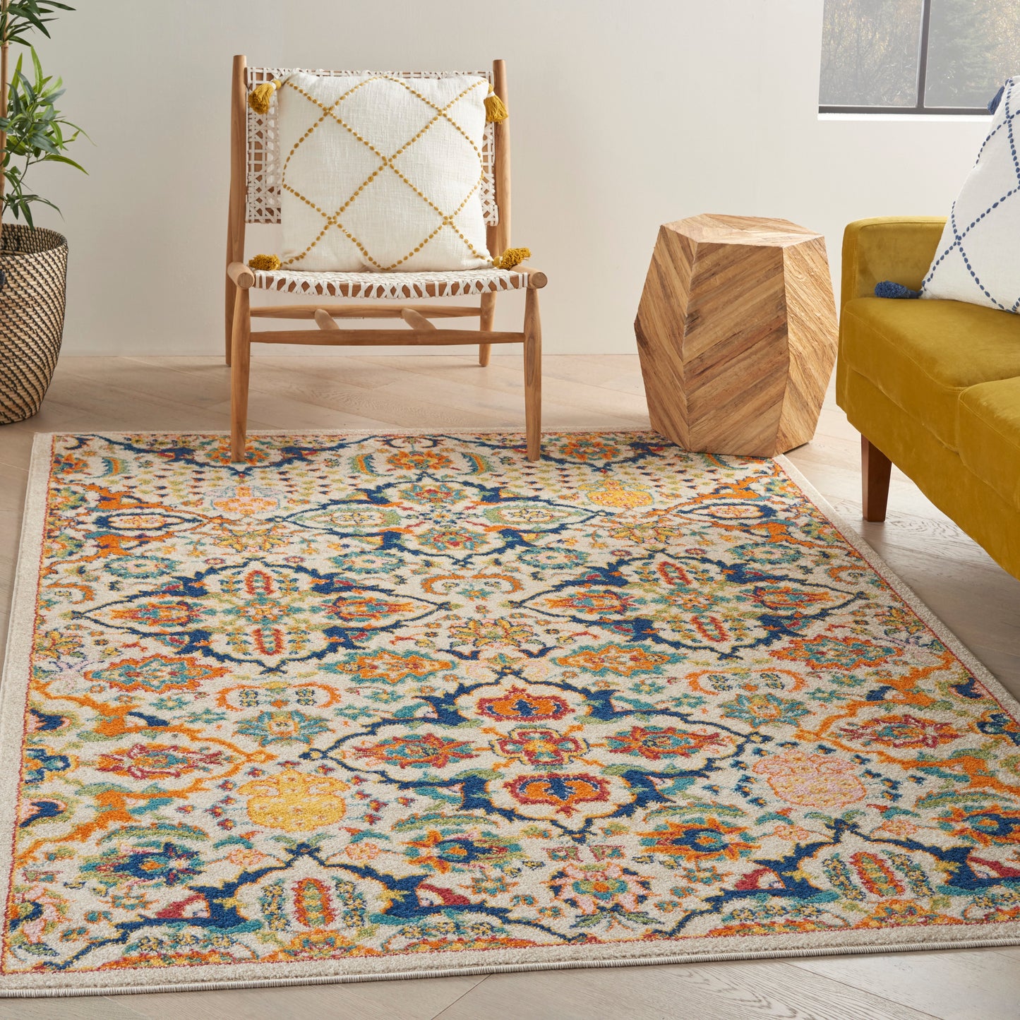 Colorful oriental-style area rug with cream background and blue, orange, yellow motifs in a modern living room