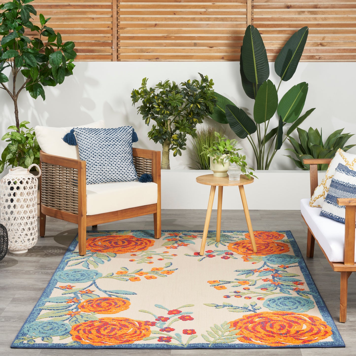 Outdoor rug with a vibrant floral pattern in orange and blue.