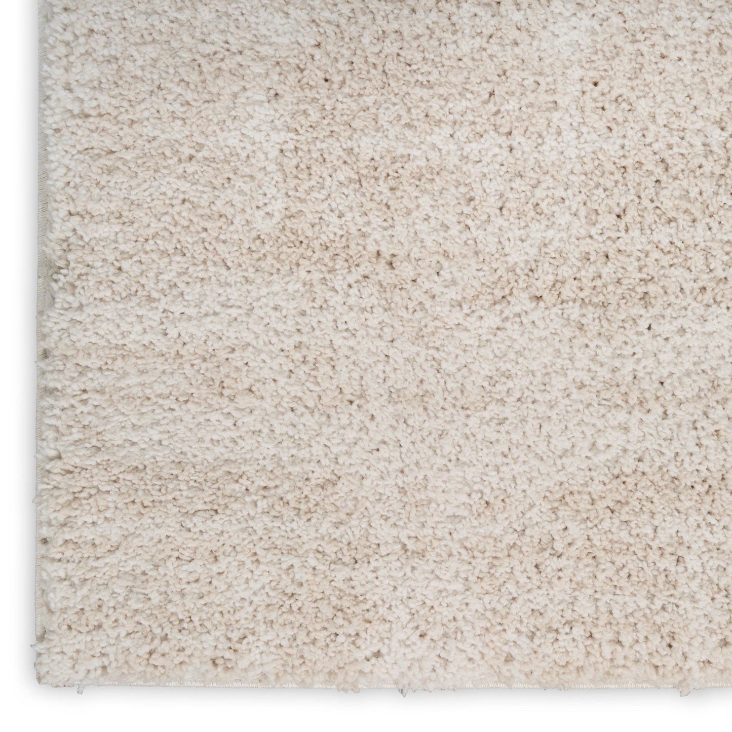 Beige plush shag rug close-up with dense cream pile and visible edge.