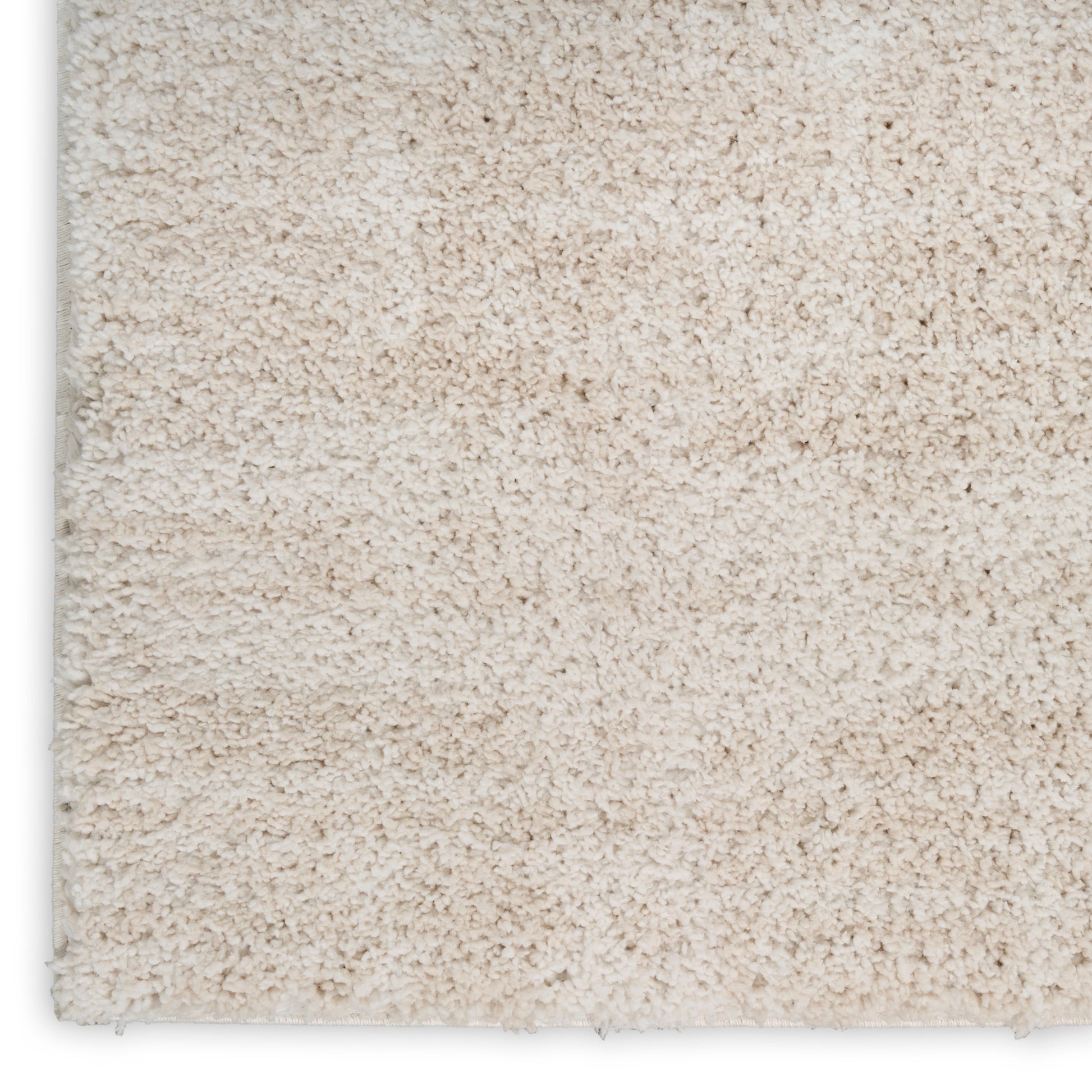Beige plush shag rug close-up with dense cream pile and visible edge.