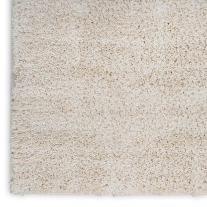 Beige plush shag rug close-up with dense cream pile and visible edge.