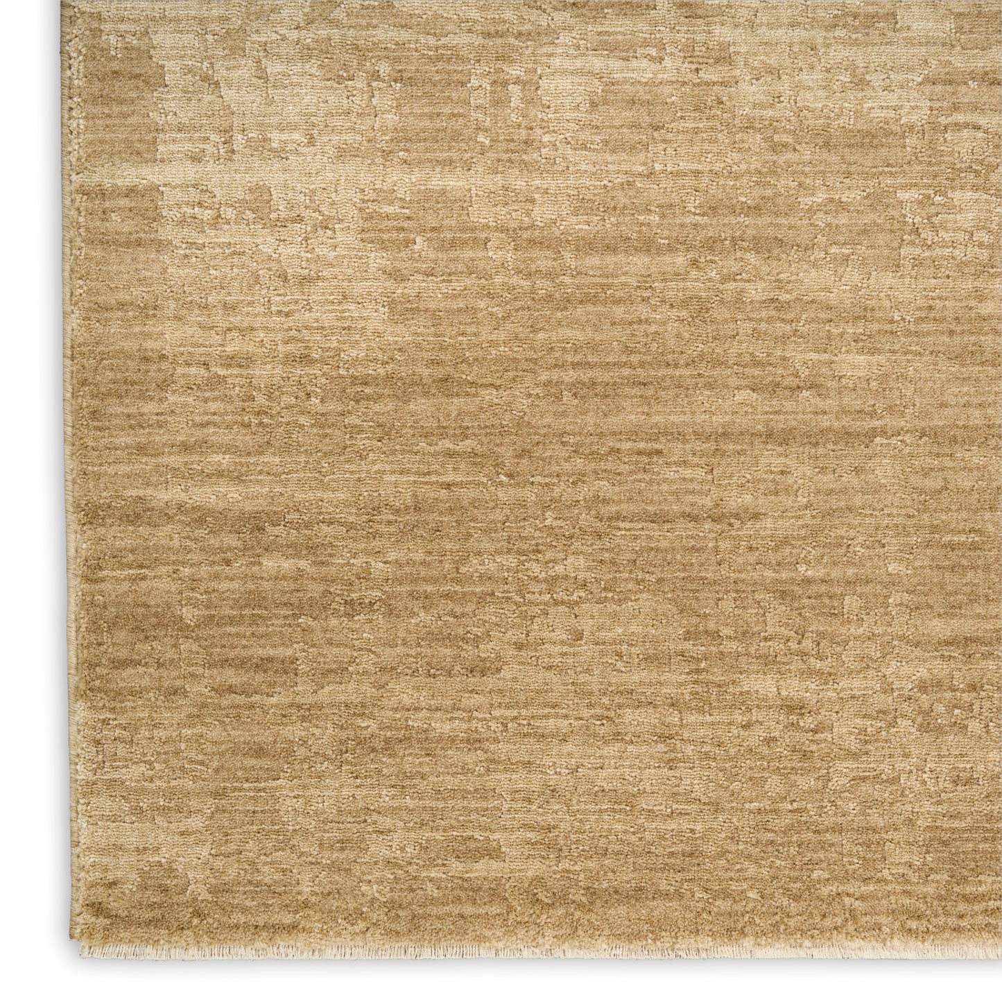 Beige-tan area rug with subtle distressed texture, low-pile feel, and white fringe along the edge.