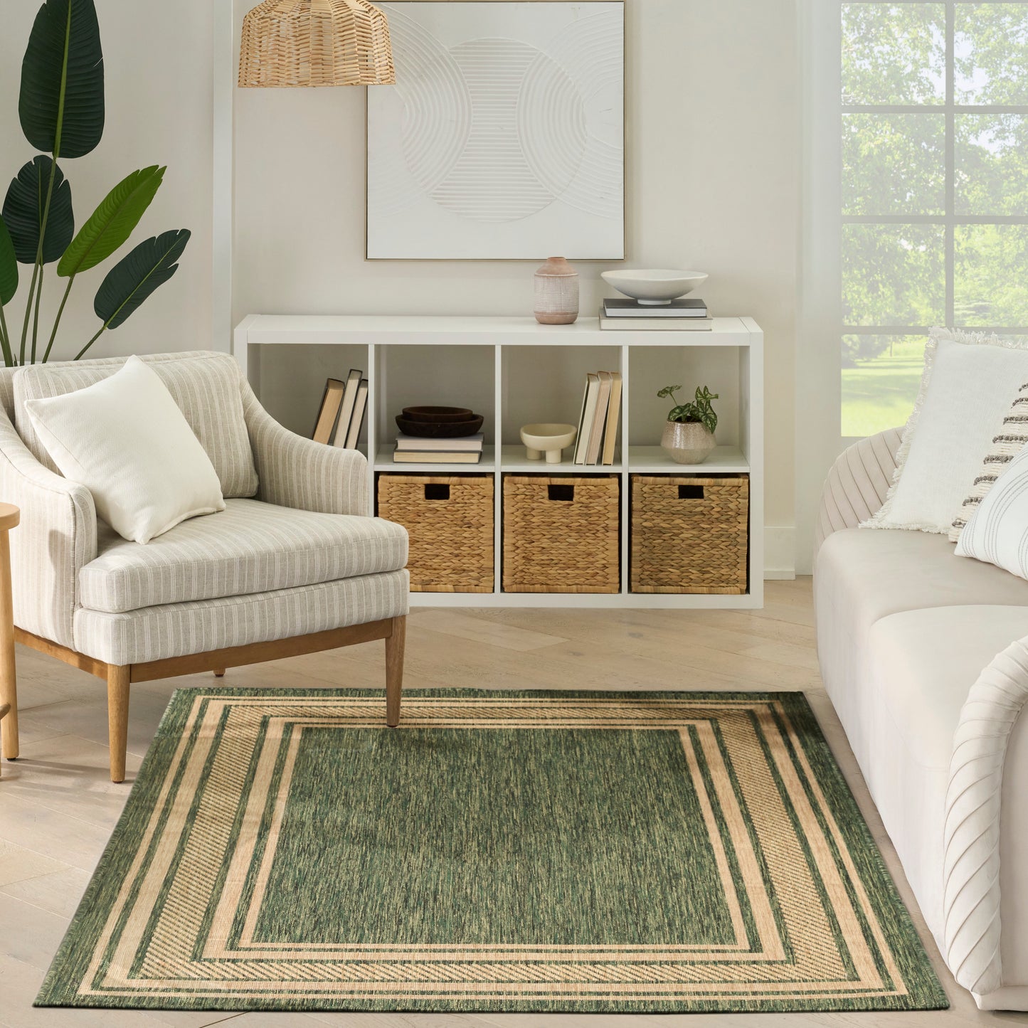 Neutral living room with a beige striped armchair, white cubby storage with wicker baskets, and a green bordered rug.