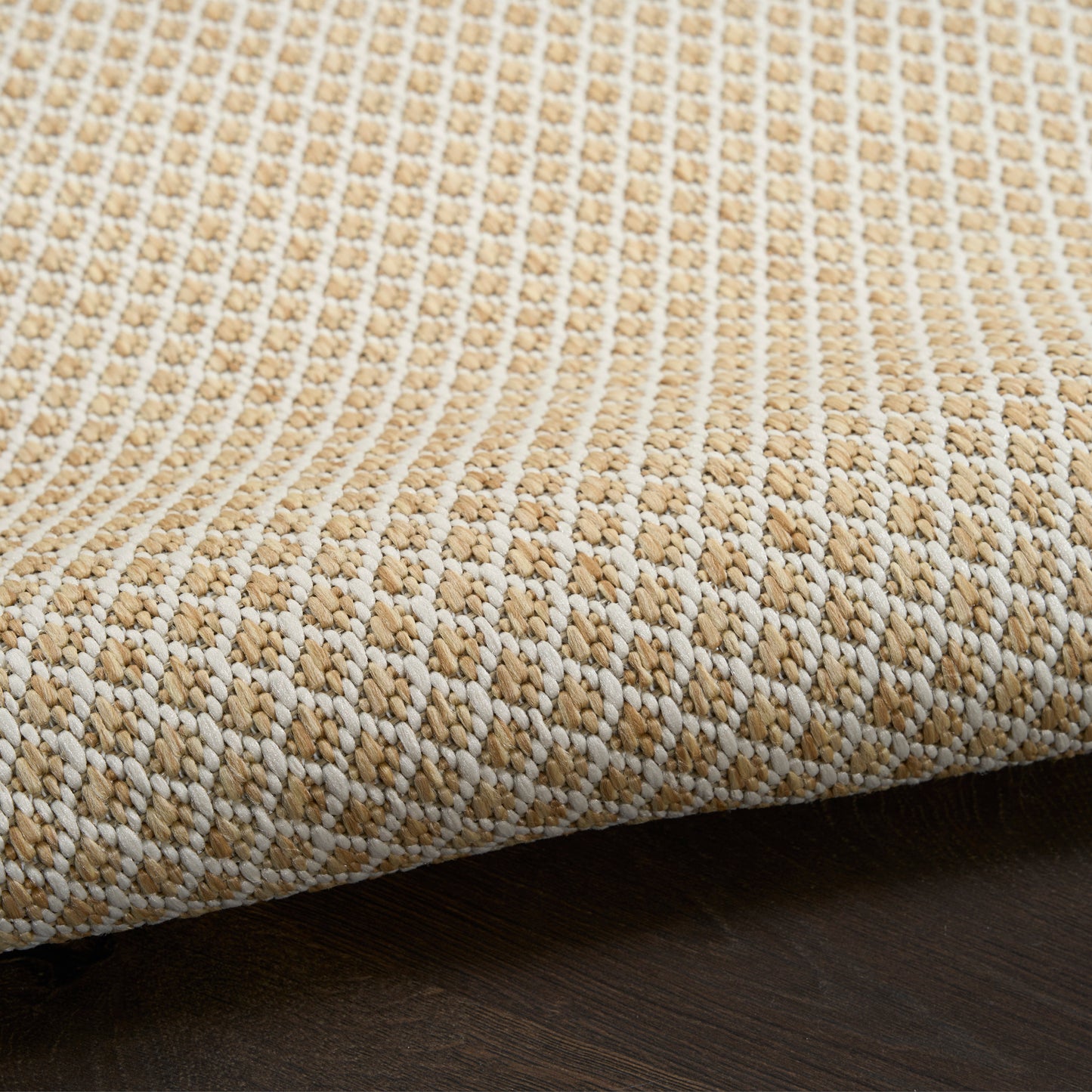 Natural beige woven rug with raised striped texture on dark wood floor.