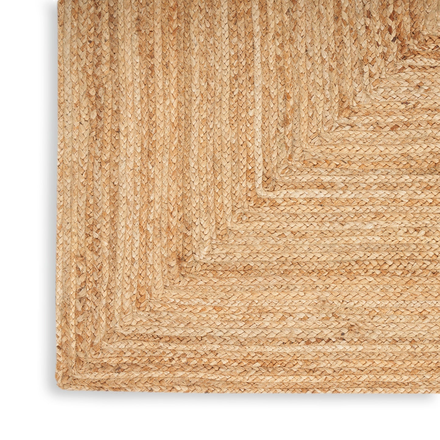 Natural jute braided rug corner in beige/tan; textured coastal rustic weave.