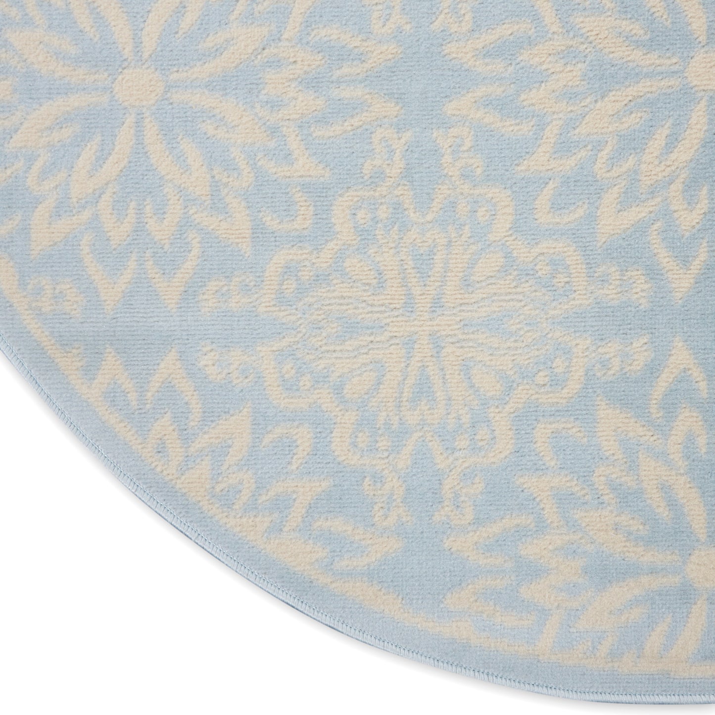 Round rug with pale blue background and ivory ornate floral medallion pattern.