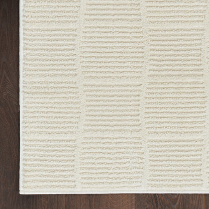 Cream textured rectangular rug with raised ribbed panel pattern on dark wood floor.