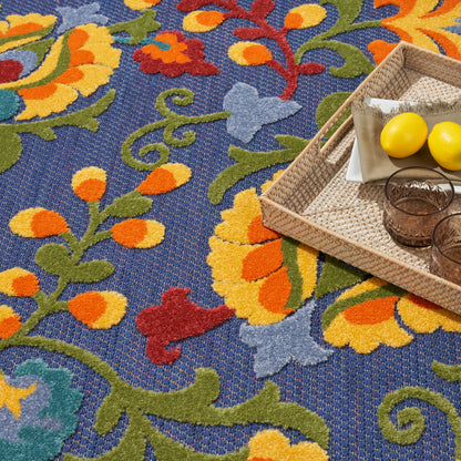 Blue patterned rug with vibrant floral motifs; woven rattan tray with lemons and amber tumblers.
