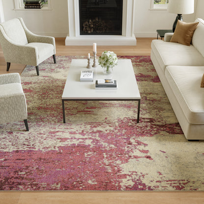 Modern living room with white rectangular coffee table, cream sofa and armchairs, pink-beige rug, fireplace and decor.