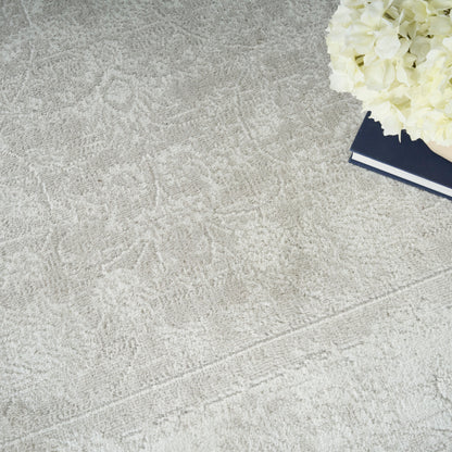 Beige textured rug with a navy hardcover book and white hydrangea bouquet in the top-right corner.