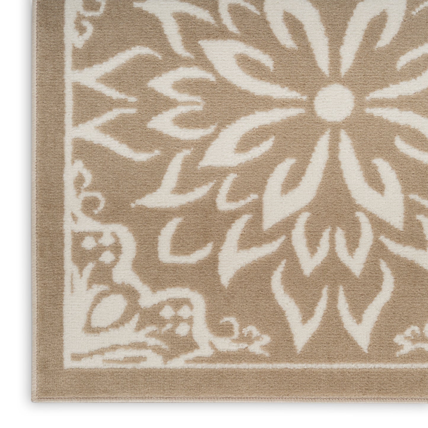 Rectangular beige-brown rug with large white floral motif and decorative border.