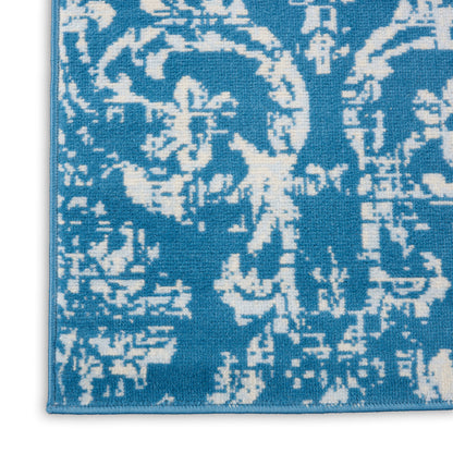 Blue damask runner rug with white floral pattern, woven texture and visible border.