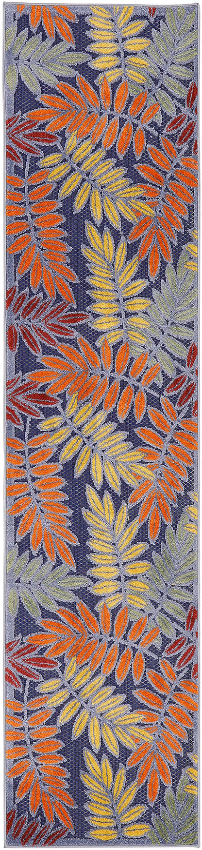Rectangular woven rug runner with bright tropical leaf pattern in orange, yellow, lime, and mint on navy background.