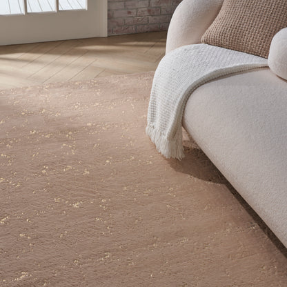 Soft blush beige textured area rug with subtle fleck beside a cream sofa and white knit throw in a sunlit living room