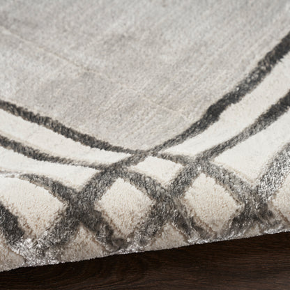 Beige & gray plush rug with dark charcoal geometric border on dark wood floor.