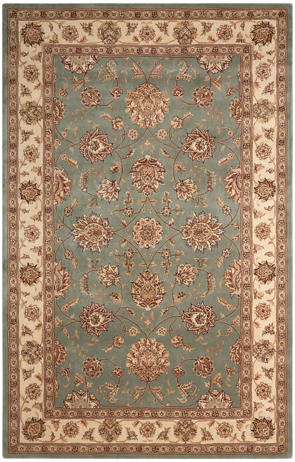 Rectangular Persian-style area rug with teal center, cream border and brown floral motifs.
